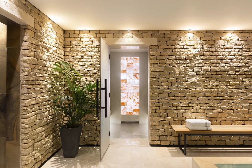 Himalayan salt steam room entrance within a spa designed by UK spa designers using natural stone and warm lighting